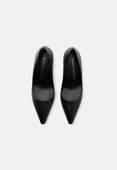 Black leather high-heeled pumps with a pointed toe and smooth texture. Interior features a gold logo detail on the insole.
