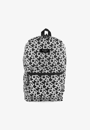 La mochila presenta un patrón en blanco y negro de letras "DKNY" superpuestas. Tiene un asa superior, correas ajustables y un bolsillo frontal con cremallera.