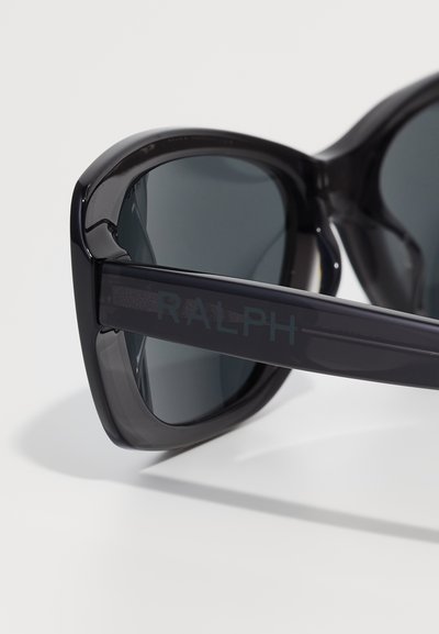 Czarne, oversize okulary przeciwsłoneczne z błyszczącego plastiku. Szare szkła w kolorze przyciemnionym oraz napis "RALPH" tłoczony na zauszniku.