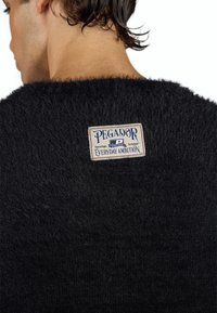 Sort, fuzzy sweater med et synligt mærke, der viser "PEGADOR" og "Everyday Ambition." Blød tekstur og løs pasform vist fra ryggen.