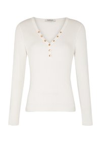 Top en tricot côtelé blanc à manches longues avec un décolleté en V, mettant en avant cinq boutons dorés le long de l'encolure pour un détail raffiné. Texture lisse sur l'ensemble.