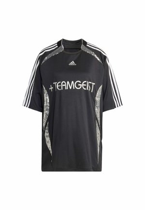 Jersey atlético negro con el texto "+Teamgeist", acentos de lentejuelas plateadas y tres franjas blancas en cada hombro. Mangas cortas, corte relajado.