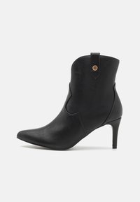 Must musta saapad terava varbaga, stiilne disain ja kõrge stilettokand. Omab dekoratiivset silmust ja peent õmblusdetaili.