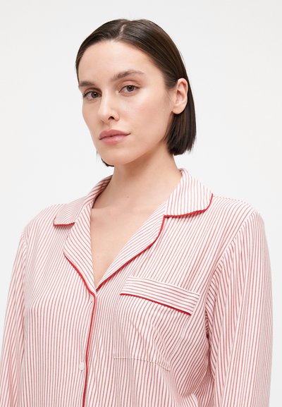 Pijama de riscas vermelhas e brancas com colarinho, fecho de botões à frente e um bolso no lado esquerdo do peito. Feito de tecido leve.