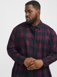 Een shirt met lange mouwen, uitgerust met een donkerrood en marineblauw ruitpatroon, knoopsluiting aan de voorkant en een ontspannen pasvorm. Gemaakt van zachte, gestructureerde stof.