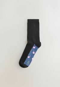 Sort sok med en sektion i denimmønster, der har pink ornamenter og et grønt trædesign. Glat tekstur hele vejen igennem.
