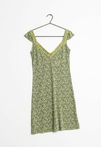Grünes blumengeblümtes Kleid mit kurzen Ärmeln, V-Ausschnitt und Spitze. Hergestellt aus leichtem Stoff, hängt an einem schwarzen Haken.