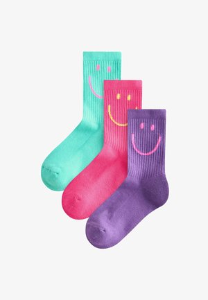 Drei Paar Crew-Socken in Teal, Pink und Lila. Jede hat eine gerippte Textur mit einem Smiley-Gesicht-Design in kontrastierenden Farben.