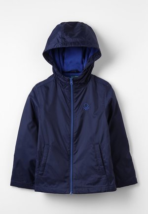 Chaqueta con capucha azul marino con cremallera frontal, dos bolsillos laterales y un pequeño logo bordado en el pecho izquierdo.