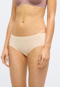 Béžové dámske hipster spodné prádlo vyrobené z hladkej látky, s bezšvovým dizajnom a stredne vysokým pásom pre pohodlie a dobré prispôsobenie.