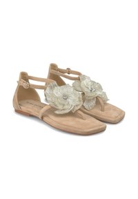 Beige suède sandalen met vierkante neuzen, met twee grote metalen bloemaccenten en een gesp sluiting op de enkelriem. Platte zool.