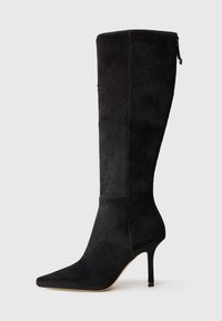 Fekete, magas sarkú csizma texturált anyagból, hegyes orral és testhezálló kialakítással, amely a vádli közepéig ér, cipzárral záródik.