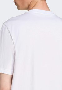 White cotton t-shirt with a crew neckline and short sleeves, featuring a smooth texture and no visible patterns or accents.