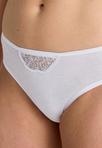 Mutande in cotone bianco con un dettaglio in pizzo nella parte anteriore. Texture morbida, design a vita media e bordi lisci per il massimo comfort.