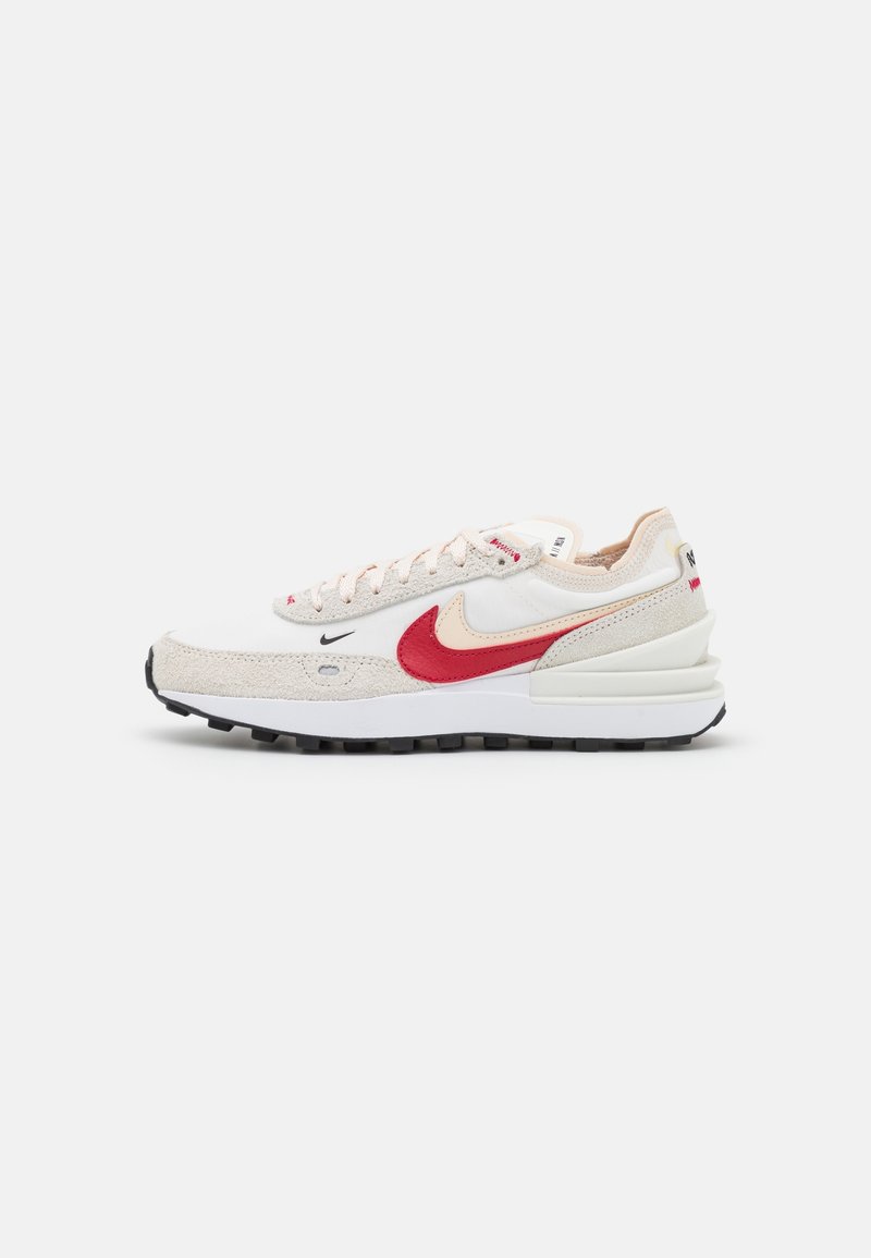 Baskets Nike blanches et beiges avec logos Swoosh doubles rouge et crème, semelle texturée et design à lacets, vues de profil sur fond blanc.