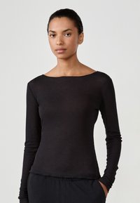 Black long-sleeve ribbed top with a wide boat neckline and a fitted silhouette, made of lightweight, slightly sheer fabric.