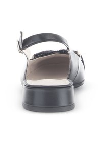 Zwarte sandaal met een lage, robuuste hak, een soepel leren bovenkant en een verstelbare achterband. De binnenkant is gevoerd met een lichtgekleurde inlegzool.