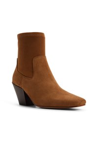 Hnědá semišová kotníková bota s špičatou špičkou, elastickým bočním panelem a zúženým dřevěným podpatkem. Hladká textura a elegantní design.