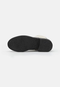 Sola de borracha preta com padrão texturizado, apresentando uma borda superior de cor clara e um acabamento suave. Design plano e durável para estabilidade.
