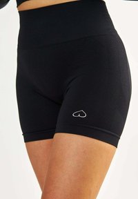 Czarne, sportowe szorty z wysokim stanem, wykonane z gładkiego materiału, z teksturowanym panelem bocznym oraz małym białym logo serduszka na dolnej części nogawki.