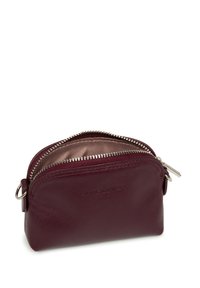 Portamonete in pelle bordeaux con forma arrotondata, chiusura a doppia cerniera e accessori in oro argenteo. Presenta un rivestimento interno a fantasia.