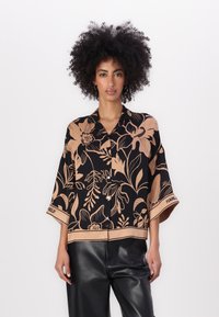 Sort blomstret bluse med beige botanisk print, korte ærmer, løs pasform og knaplukning. Inkluderer et brandlogo langs sømmen.