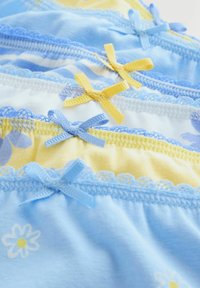 Stivă de lenjerie pentru fete în culori pastelate, cu margini din dantelă și fundițe decorative mici în albastru și galben.