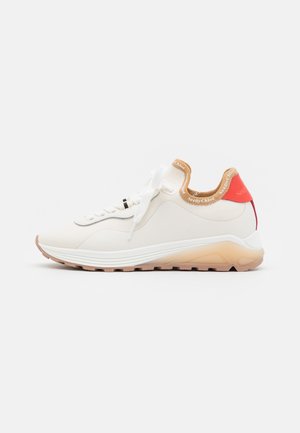 Hvid sneaker med beige accenter, tyk sål, hvide snørebånd, polstret krave med teksten "SeeByChloé" og rød hælflap på ensfarvet baggrund.