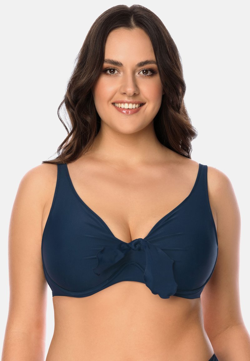 Top bikini di colore blu navy con una texture liscia, spalline larghe e un dettaglio a fiocco centrale. Presenta una scollatura profonda e una leggera arricciatura.