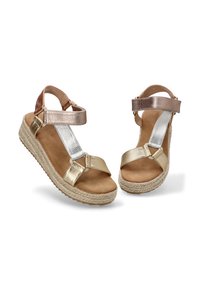 Sandalias espadrilles metálicas en oro y plata con tira en el tobillo, abertura circular para los dedos y suela de yute trenzado. Textura suave y diseño minimalista.