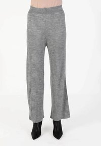 Graue gerippte Strickhose mit breitem, elastischem Bund. Sie hat eine glatte Textur und einen weit ausgestellten Saum, kombiniert mit schwarzen spitzen Knöchelstiefeln.