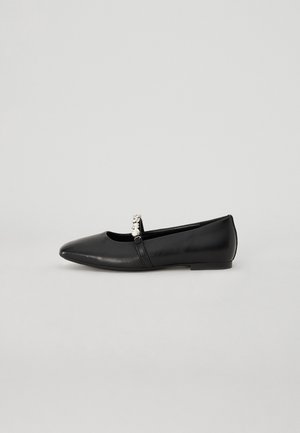 Ballerines en cuir noir avec un bout pointu, présentant un petit accent métallique sur la sangle et une semelle plate et minimaliste.