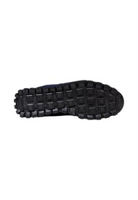 Suela de zapato de goma negra con un patrón de textura, que presenta formas rectangulares elevadas para agarre y estabilidad.