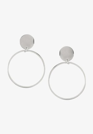 Boucles d'oreilles en métal argenté avec des clous ronds et de grands anneaux fins et circulaires suspendus sous chaque clou sur un fond blanc.