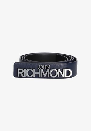 Opgerolde zwarte leren riem met grote zilveren letters die "RICHMOND" spellen en kleinere letters "JOHN" erboven.