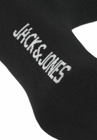 Schwarze Baumwollsocken mit einem weißen Logo-Text "JACK & JONES", der auf der Vorderseite gestrickt ist, glatte Textur und standardmäßige Sockform.