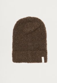 Béret en tricot marron, texture douce, sommet effilé et bord replié ; présente une petite étiquette blanche sur le côté.