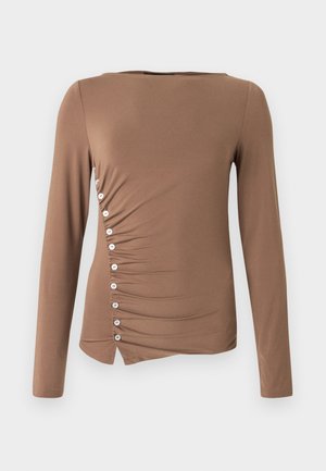 Bluză maro cu mâneci lungi din material elastic, cu design cu adunături pe partea laterală, cu nasturi albi de-a lungul cusăturii stângi și tiv asimetric.