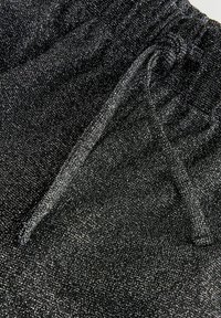 Zwarte short van gestructureerde stof met metalen zilverkleurige glinsters, voorzien van een elastische tailleband en een trekkoord.