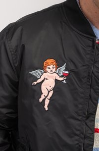 Black bomber jacket featuring an embroidered design of a cherubic figure with orange hair and a wine glass, set against a smooth fabric.