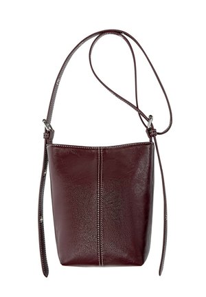 Borsa a secchiello in pelle marrone scuro con cuciture visibili e tracolla regolabile su sfondo bianco.