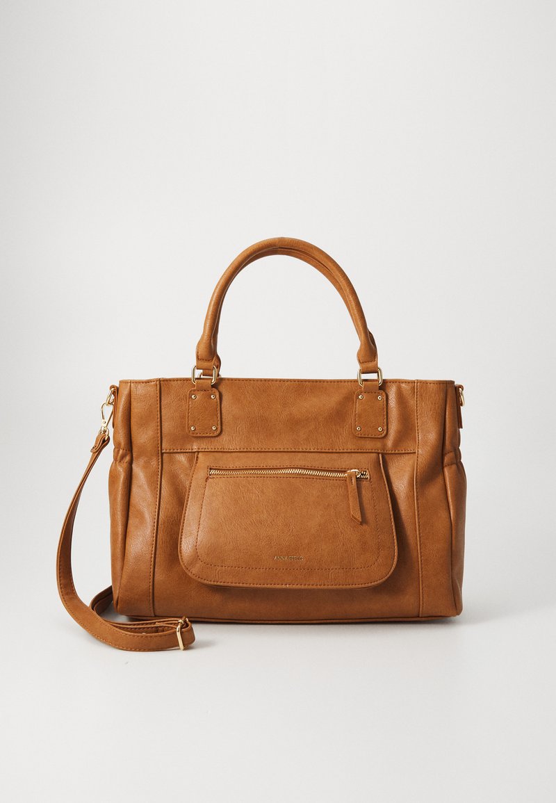Sac à main en cuir marron avec poignées doubles, bandoulière réglable, grande poche zippée à l'avant et accents dorés. Texture lisse et forme structurée.