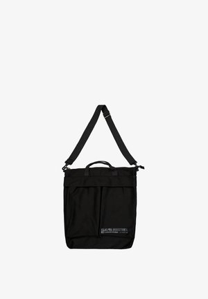 Schwarze rechteckige Tote-Tasche mit verstellbarem Schulterriemen, Griffen, Frontreißverschlusstasche und kleinem Alpha Industries-Logo unten rechts.