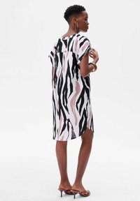 Korte mouwen, knielange jurk in zwart, wit en blush zebra print, met zijslits en een ontspannen silhouette.