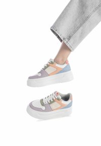 Le sneakers presentano un mix di camoscio e pelle in toni pastello di viola, pesca, verde e blu, con una spessa suola bianca e una punta perforata.