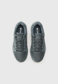 Graue Sportschuhe mit einem strukturierten Mesh-Obermaterial, verstärkter Zehenkappe und elastischen Schnürsenkeln. Besitzt eine geformte Ferse und ein Logo auf der Innensohle.