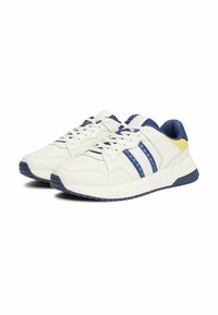 Białe trampki z niebieskimi, żółtymi i granatowymi akcentami. Perforowana cholewka i płaskie sznurowadła. Wyściełana podeszwa z teksturowanym bieżnikiem. Sportowy design.