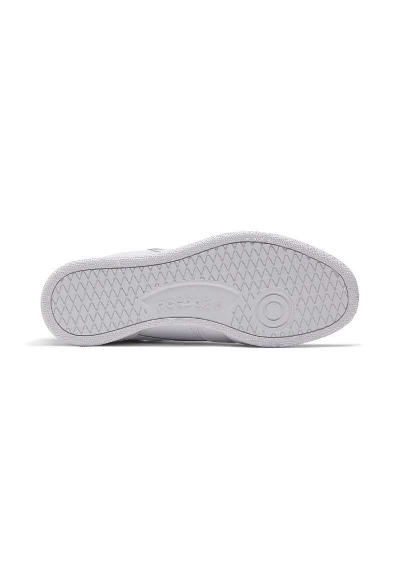 Die Sohle des weißen Sneakers verfügt über ein strukturiertes Muster für besseren Halt, mit einem runden Logo und dem eingeprägten Markennamen "Reebok" an der Seite.
