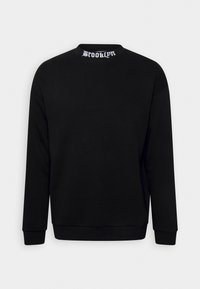 Maglione nero con maniche lunghe, scollatura rotonda e la scritta bianca "BROOKLYN" sul colletto posteriore. Texture liscia, design casual.