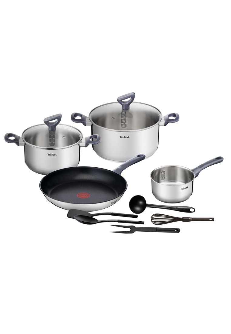 Edelstahl-Kochgeschirrset in Silber mit einer schwarzen Antihaft-Pfanne. Enthält Töpfe, einen Messbecher, eine Kelle, einen Schneebesen und Utensilien.